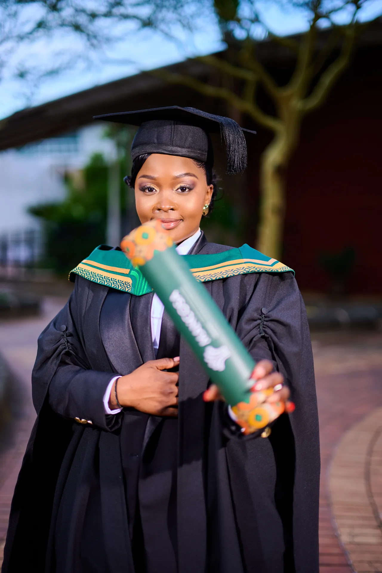 Graduate holding a diploma in cap and gown