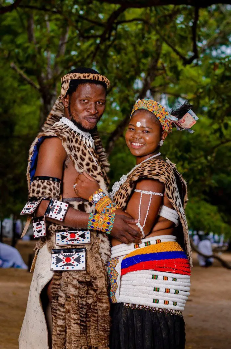 Couple in traditional wedding attire sharing a portrait outdoors